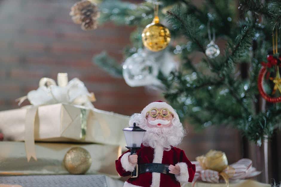 Santa Claus toy near gift boxes under Christmas tree