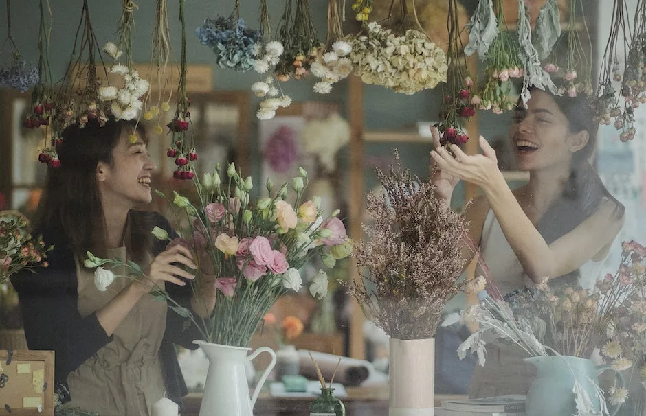 Joyful female florists working together in floral store