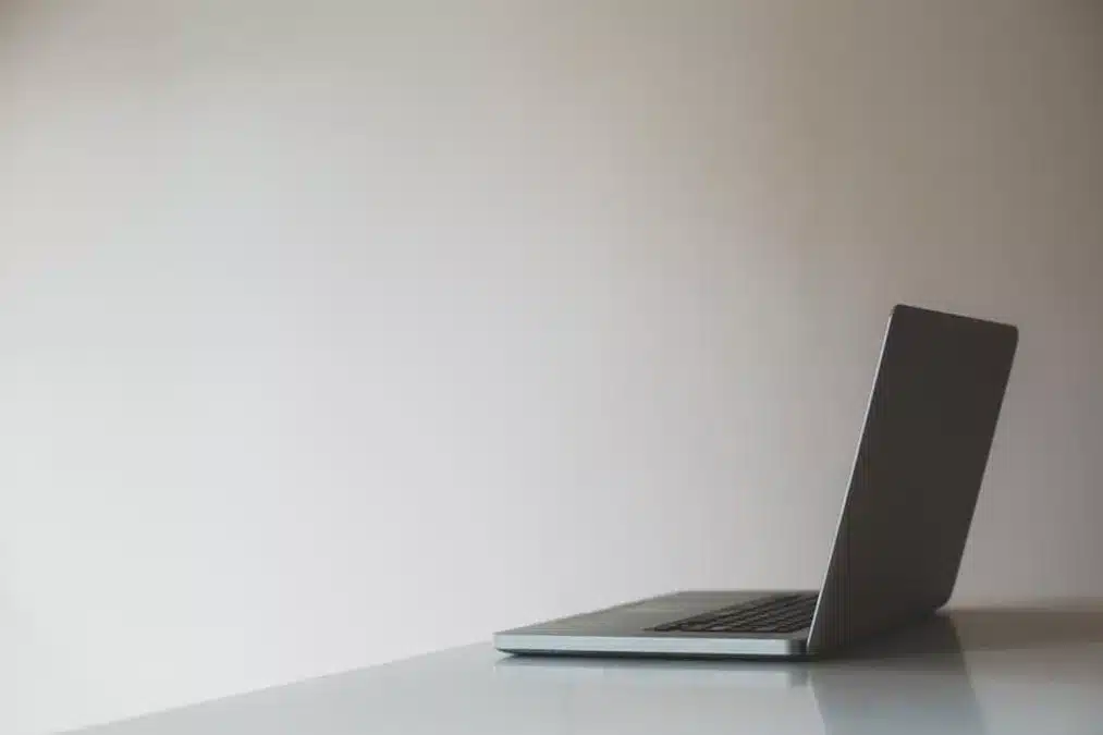 a laptop computer on a desk with a laptop - laptop in an empty room