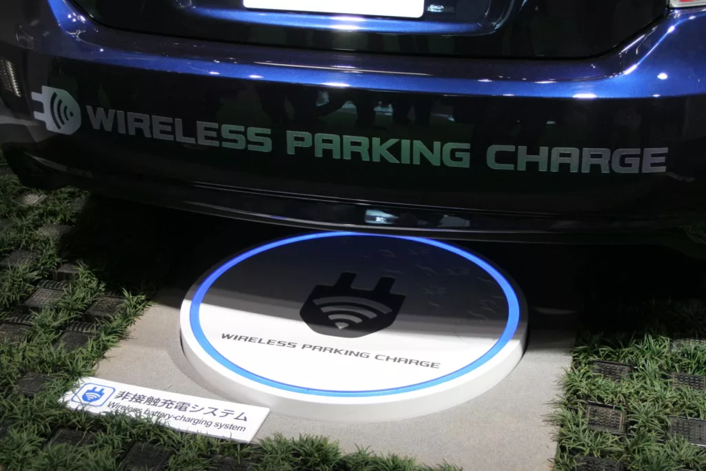File:Electric car wireless parking charge closeup.jpg - a car parked on a sidewalk with a blue circl