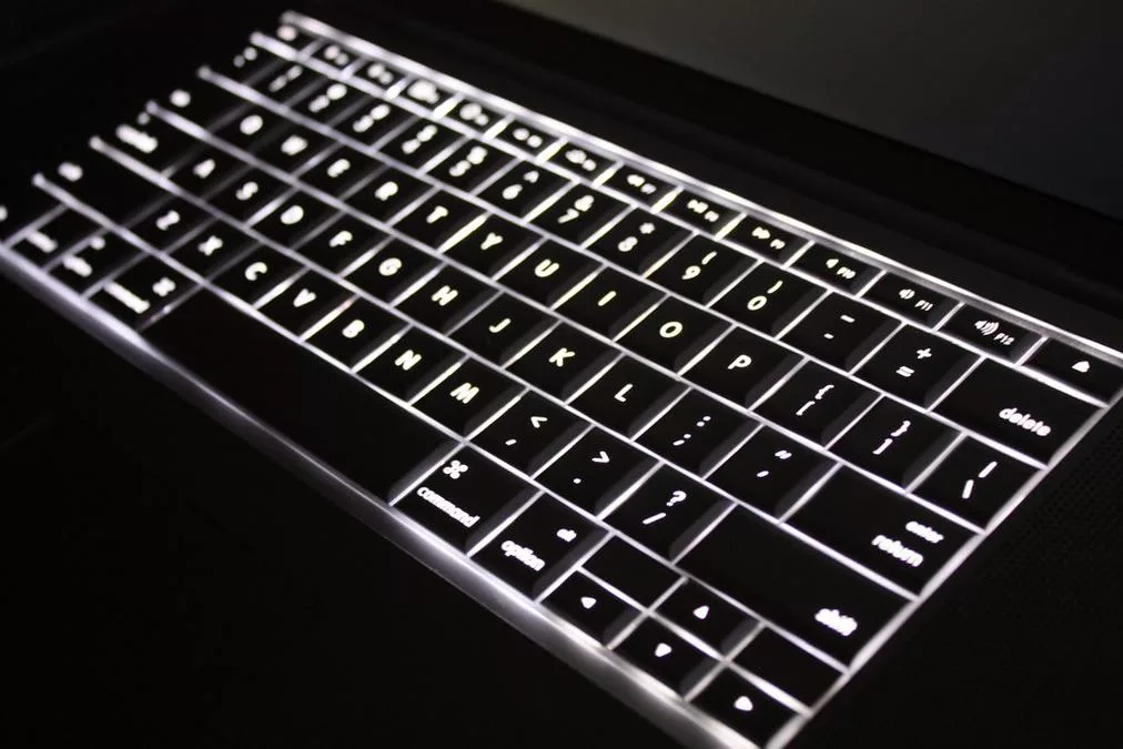 Macbook Pro keyboard backlit - a close up of a keyboard with a light on it
