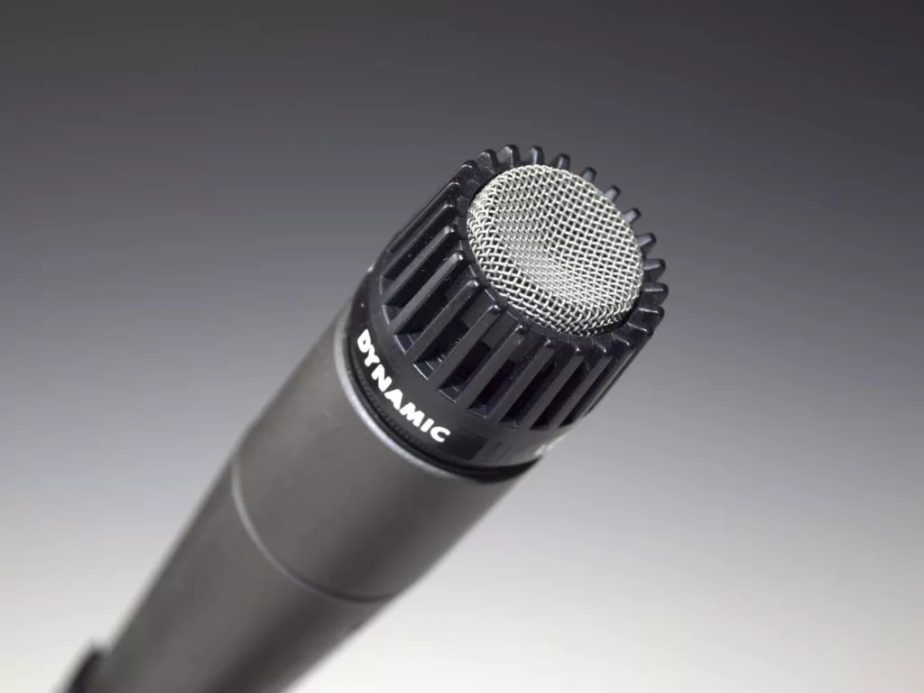 Microphone closeup, singing equipment - a close up of a microphone on a white surface