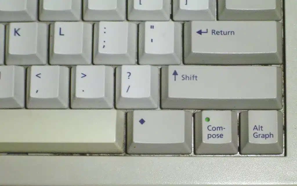 File:Compose key on Sun Type 5c keyboard.jpg - a close up of a keyboard with a green button